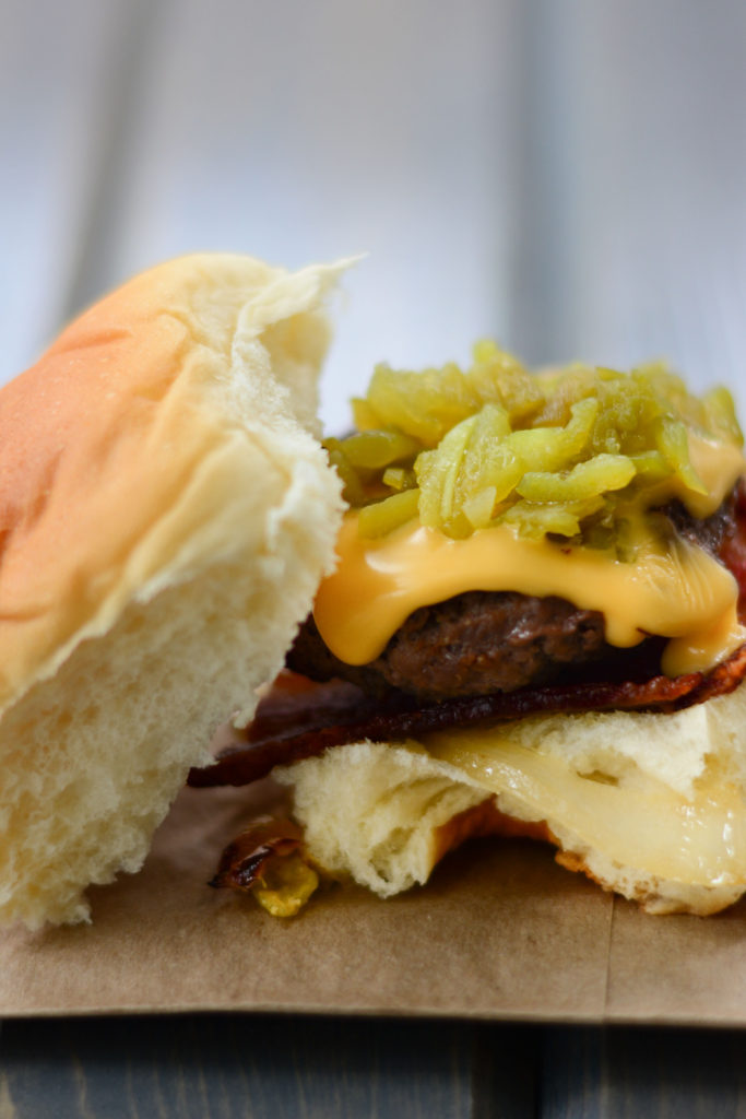 Hatch Green Chile Sliders: sweet Hawaiian roll, with a mini hamburger patty, roasted Hatch Green Chilies, sweet sautéed onions, crisp bacon, and cheese. 