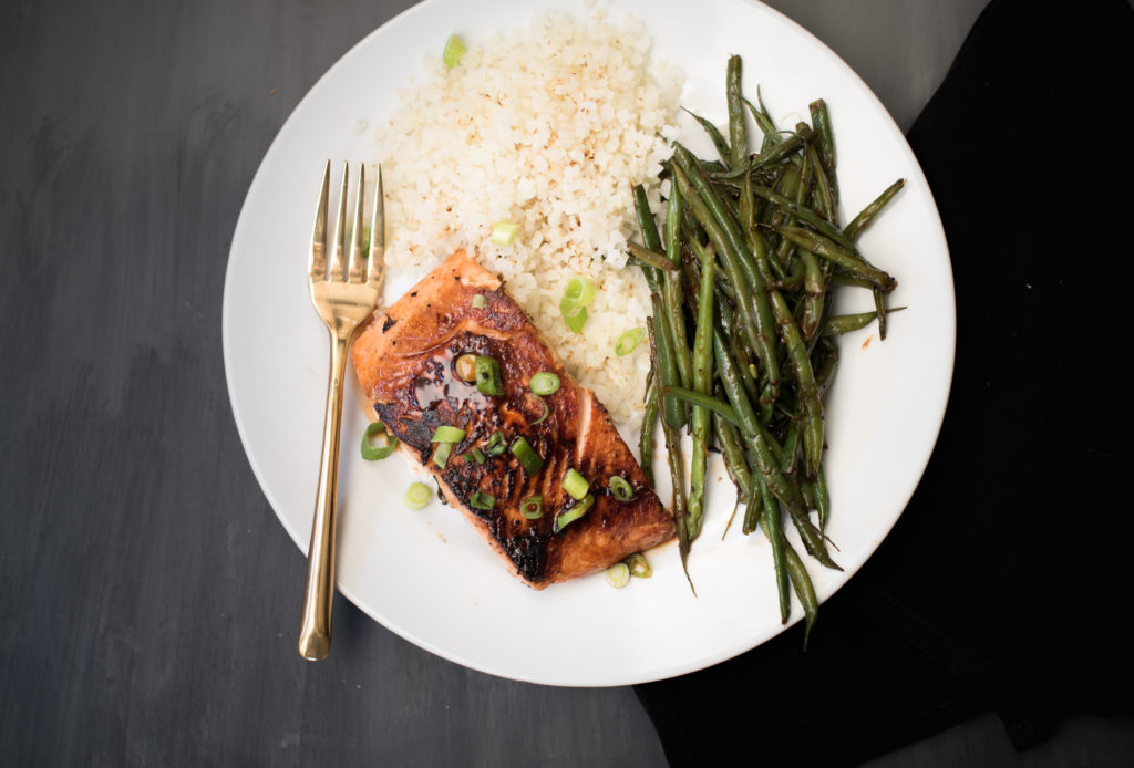 An easy 5 ingredient honey Sriracha salmon dish. A little sweet, a little spicy, and really tasty! The salmon cooks fast on the stove and is great served over rice with your favorite green vegetable. | Firstandfull.com