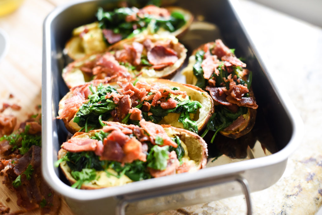 A fun, hand held breakfast option: Crispy Breakfast baked potato skins topped with scrambled eggs, garlicky spinach, chopped, crispy bacon, and a dollop of fresh pesto. Plus, tons of ways to customize and change things up! 