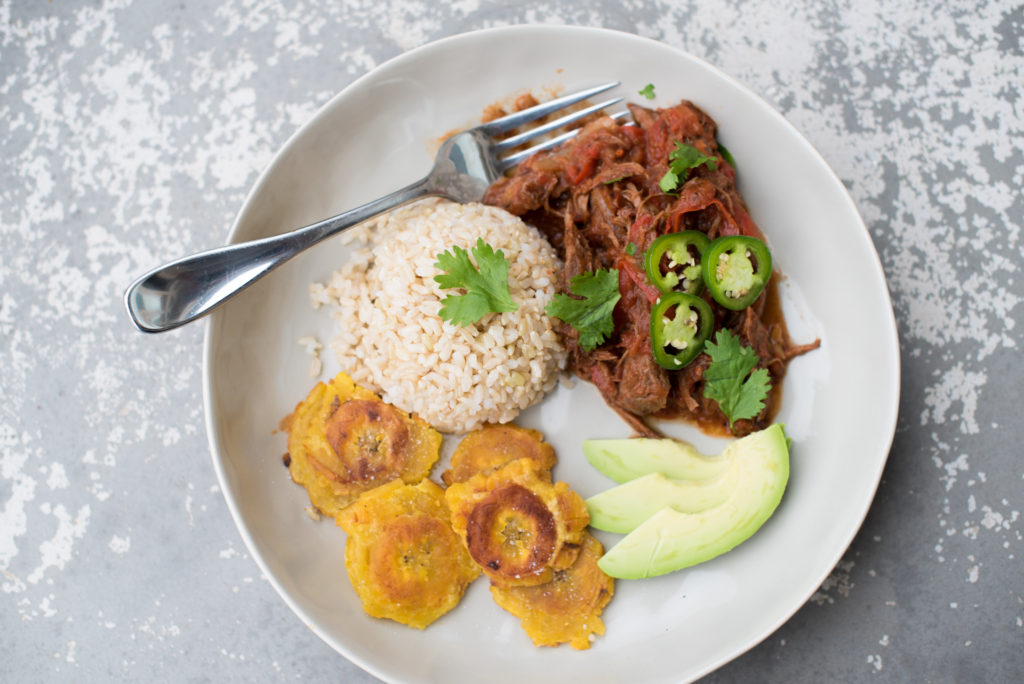 Slow Cooker Ropa Vieja: Savory shredded beef left to simmer in a delicious tomato based sauce best served over rice with a side of sweet plantains! 