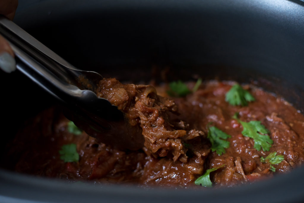 Slow Cooker Ropa Vieja: Savory shredded beef left to simmer in a delicious tomato based sauce best served over rice with a side of sweet plantains! 