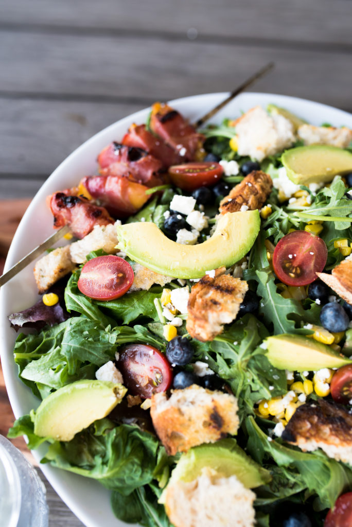 This Grilled Prosciutto wrapped peach panzanella salad is a light and delicious summer salad with grilled prosciutto-wrapped peaches, sweet blueberries, crumbled feta, grilled sourdough and charred corn.